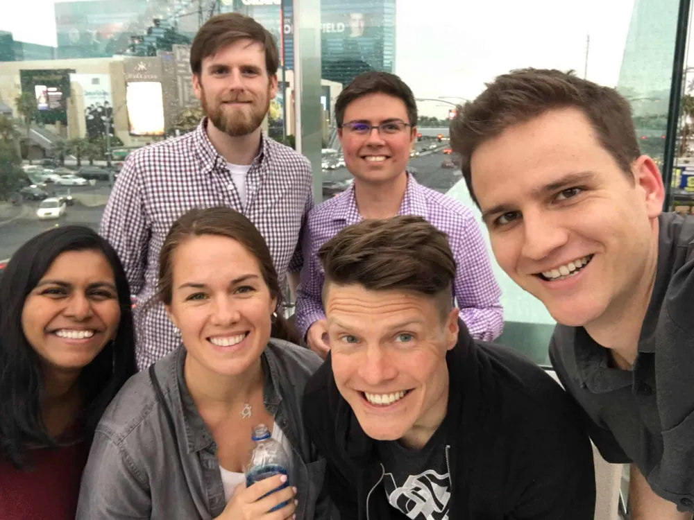 Six MegaMaker community members smiling together on a balcony